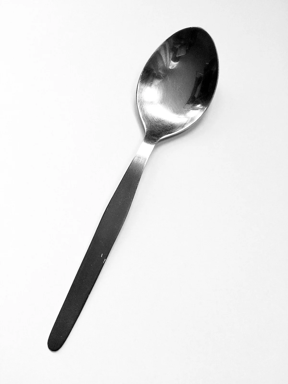 스테인리스 수프 숟가락을 촬영한 흑백 사진